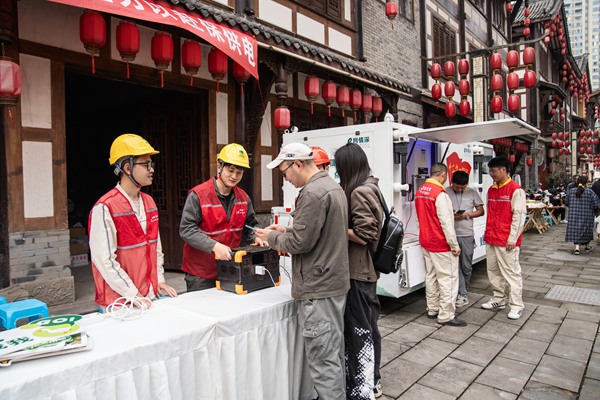 在夏布小鎮，電力志愿者為游客提供免費充電服務。賴小龍攝