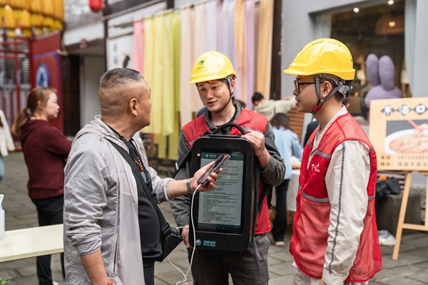 電力志愿者利用移動充電包為游客提供免費充電服務。賴小龍攝