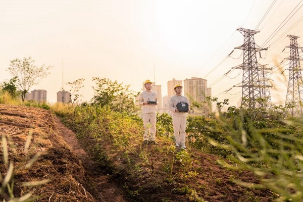 何濤（左一）利用無人機開展巡檢工作。國網重慶永川供電公司供圖