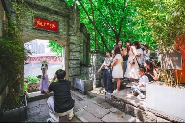 游客們在標志性景點拍照。龍門浩老街供圖