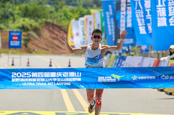 選手沖過終點線，雙臂高舉展現勝利的喜悅。王京華攝