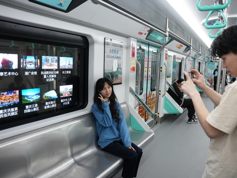 乘客打卡重慶軌道交通18號線智慧車窗。謝茂攝