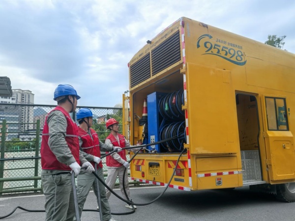 國家電網重慶電力（城口綜合）紅巖共產黨員服務隊隊員在城口中學施放中壓電源車電纜，為接入2025年高考考點線路做準備。國網城口供電公司供圖