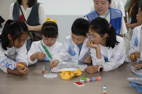 6月8日，孩子們為“禁止吸煙”環保袋涂鴉。付軍攝