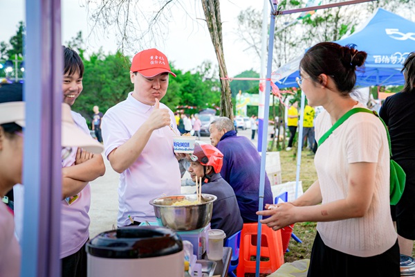 遠道而來的游客為當地特色美食點贊。主辦方供圖