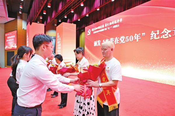 為“光榮在黨50年”老黨員獻花。林豪攝