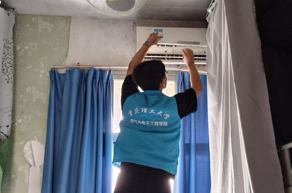 志愿者正在取下空調濾網。重慶理工大學供圖