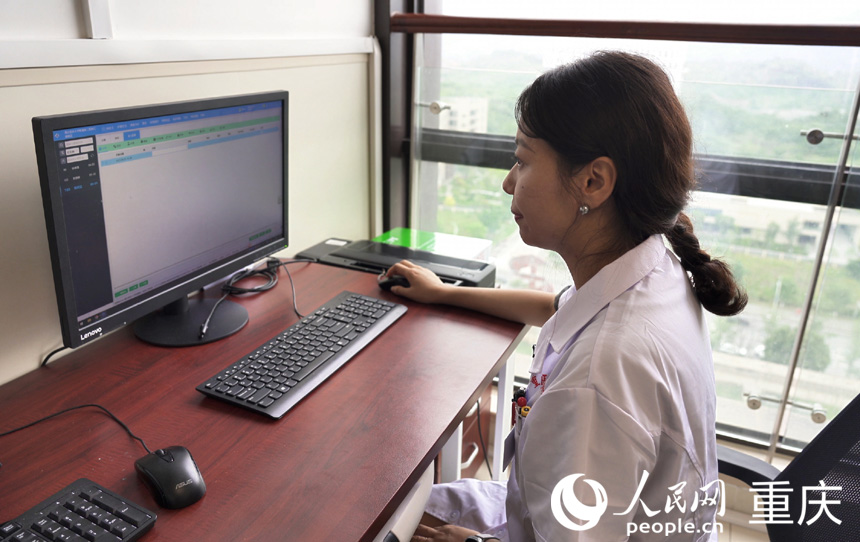 重醫附二院江南院區，醫生通過醫檢互認系統，查看患者在當地的檢查結果。人民網記者 劉祎攝