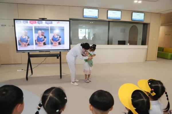 萌娃在醫院工作人員的指導下學習海姆立克急救方法。趙海攝