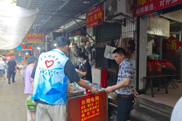 志愿者給商戶發放反詐傳單。重慶財經學院供圖