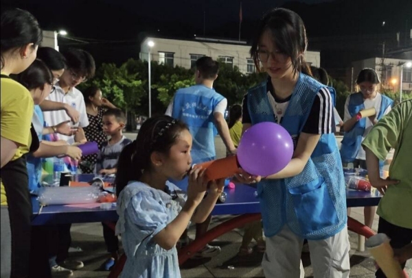 志愿者和小朋友一起體驗“火箭”升空。重慶師范大學物理與電子工程學院供圖