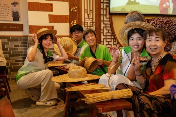 團隊成員與回龍壩鎮老人一起編織草帽。甘世杰攝