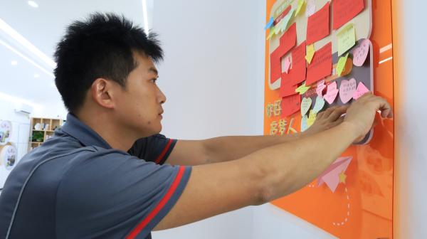 快遞小哥將心愿貼上“騎士心愿墻”。楊妮沙攝