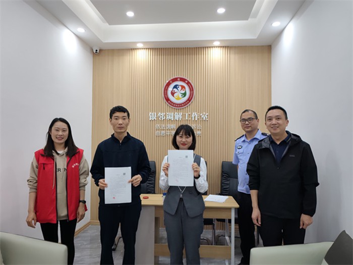 社區民警、網格員成功調解謝先生與李女士矛盾糾紛，雙方握手言和。通訊員 王軒 攝