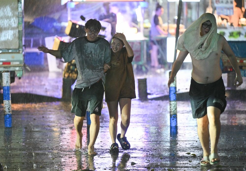 8月6日晚，南岸區水云路，市民開心地行走在暴雨中。記者 謝智強 攝