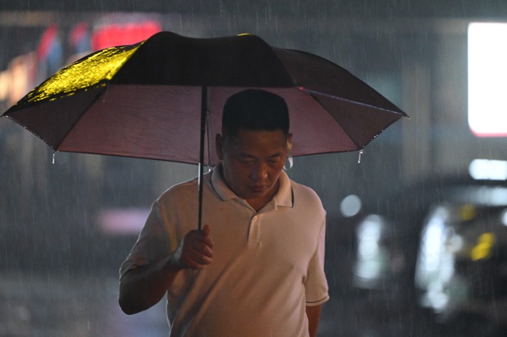 8月6日晚，南岸區水云路，市民行走在暴雨中。記者 謝智強 攝