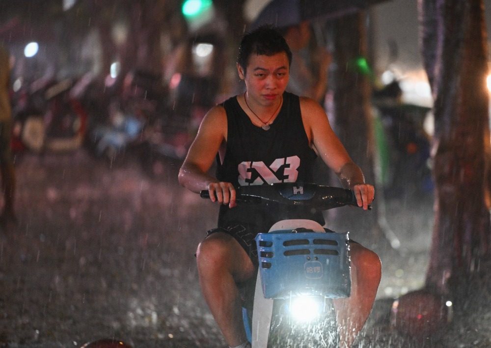 8月6日晚，南岸區水云路，市民在暴雨中騎行。記者 謝智強 攝