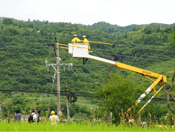 媒體記者在綦江區東溪鎮拍攝供電員工引流線搭接工作。袁巧攝