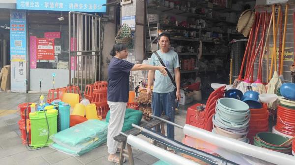 張欽庭規勸占道經營的攤主。東溫泉鎮供圖