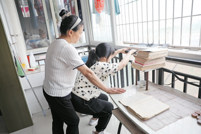 李遇梅攥著女兒僵硬的身體不斷練習下蹲。楊青攝