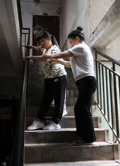 李遇梅正扶著女兒下樓。趙英如攝