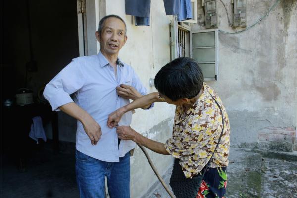 銀齡志愿者為老人整理衣服。鄒冰倩攝