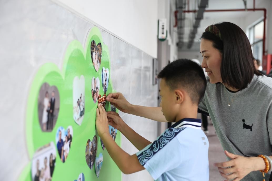 勉仁小學一年級新生在成長樹上貼全家福。晏瀅瀅攝