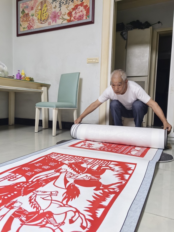 郭文友展示剪紙作品《銘記歷史 振興中華》。江津區委宣傳部供圖