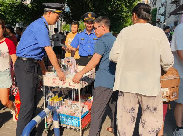 城管隊員幫助攤販規范占道經營。巴南區城市管理局供圖