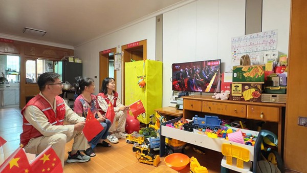 9月3日，重慶市雙橋經開區連二坡社區，國網永川供電公司雙橋供電中心員工鐘沉霞、黃洋勇等人在開展網格服務時，與居民周富強收看紀念大會和閱兵儀式直播。宋元攝