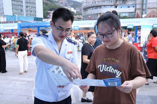 奉節縣稅務人員在公平競爭政策宣傳活動現場向市民宣傳納稅信用管理相關政策。孫艷嬌攝
