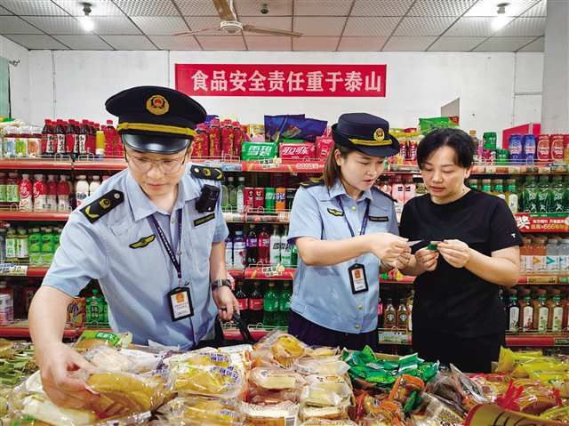 市場監管工作人員對商超銷售食品進行日常檢查