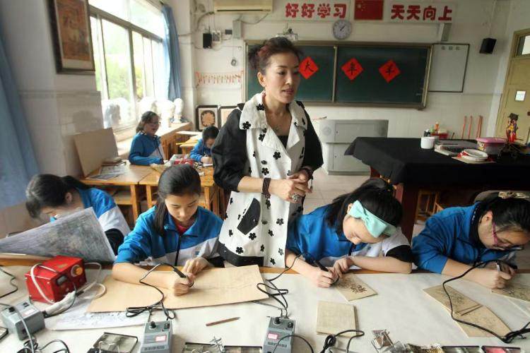 高磊老師在指導學生制作烙畫。